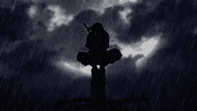 a silhouette of a person standing in the rain with a full moon in the background .