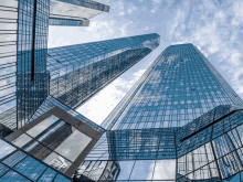 looking up at a skyscraper with a reflection of another building