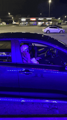 a man is sitting in a car in front of a domino 's