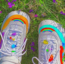 a pair of white sneakers with rainbows painted on the laces