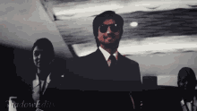 a man in a suit and tie is standing in a dark room with shadowedits written on the bottom