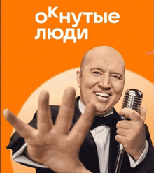 a man in a tuxedo is holding a microphone and smiling in front of an orange background that says oknytbie