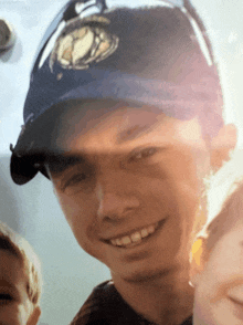 a young boy wearing a blue hat with a baseball logo on it