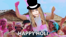 a woman in a top hat says happy holi in front of a crowd