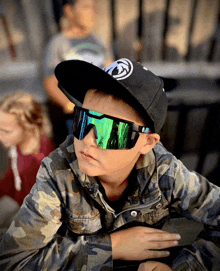 a young boy wearing a black hat and sunglasses