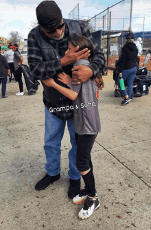 a man hugging a little girl whose shirt says grampa & sofia on it