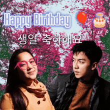 a man and a woman are sitting in front of a sign that says happy birthday in white lettering