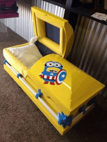 a yellow coffin with a picture of a minion on the lid