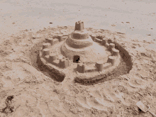 a sand castle on a beach with a pink shovel