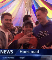 a man wearing a nike sweatshirt is giving a peace sign in front of a crowd