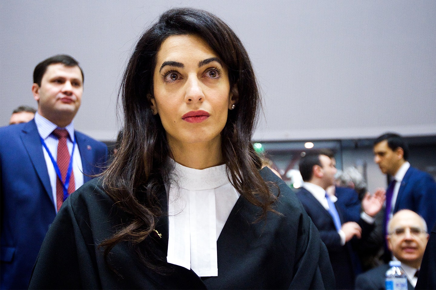 Image may contain Tie Accessories Accessory Human Person Coat Clothing Overcoat Apparel Suit and Amal Clooney