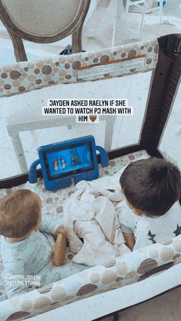 two babies sitting in a crib with a tablet that says jayden asked raelyn if she wanted