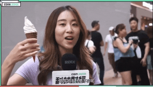 a woman holding an ice cream cone with a rode microphone