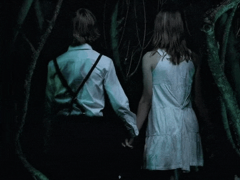 a man and a woman are holding hands in the dark .