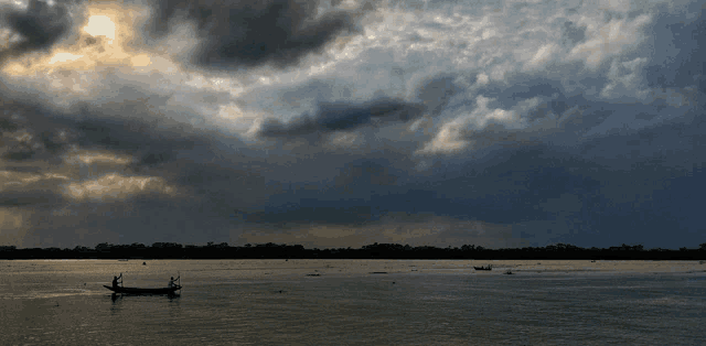 the sun is shining through the clouds over a lake