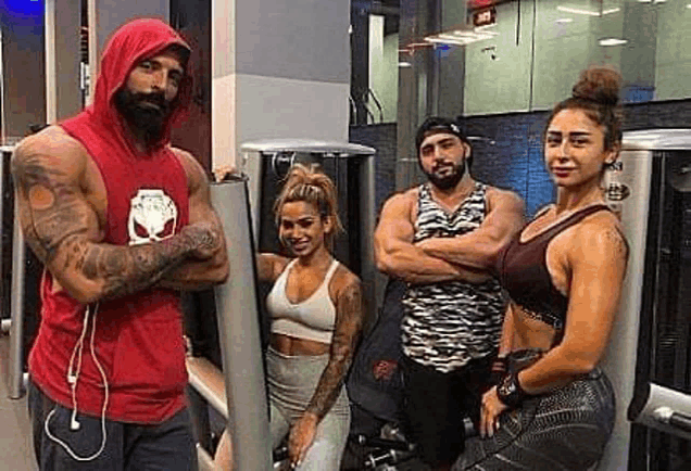 a group of people are standing in a gym with their arms crossed .