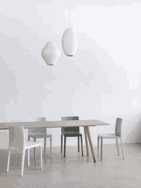 a table and chairs in a room with a white wall behind them