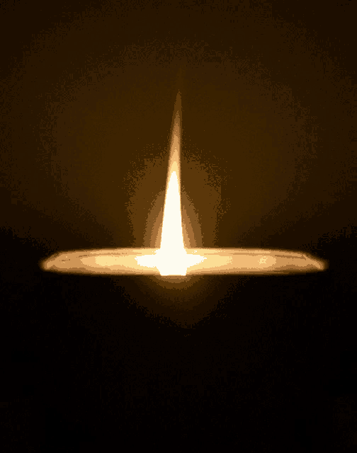 a candle is lit up in the dark with a single flame coming out of it