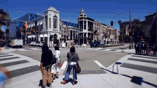 a group of people are crossing a street in front of a building that says ' o'neill ' on it