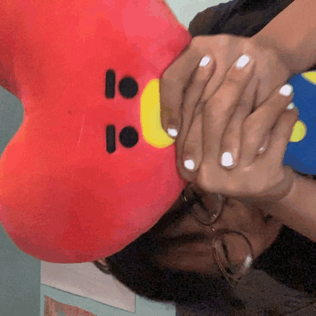 a person covering their face with a stuffed animal with the number 10 on its face