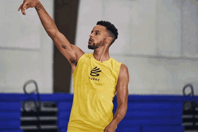 a man wearing a yellow tank top with the word curry on the front