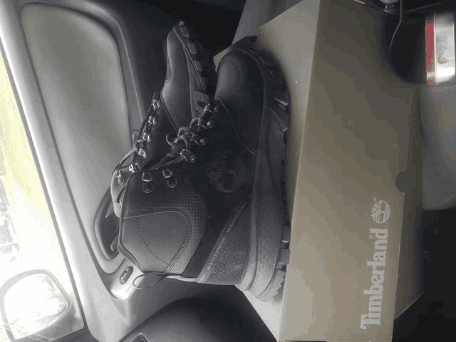 a pair of black timberland boots on top of a timberland box