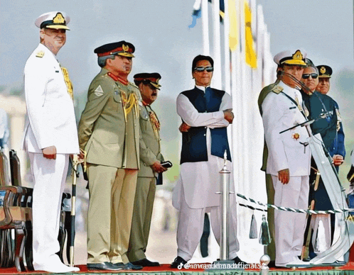 a group of men in military uniforms standing in front of flags