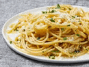 a close up of a plate of spaghetti with cheese on a table .