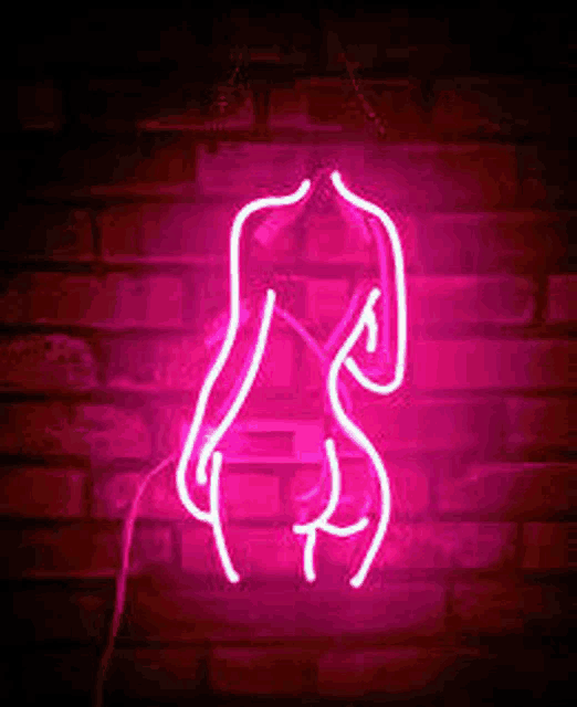 a neon sign of a woman 's torso against a brick wall .