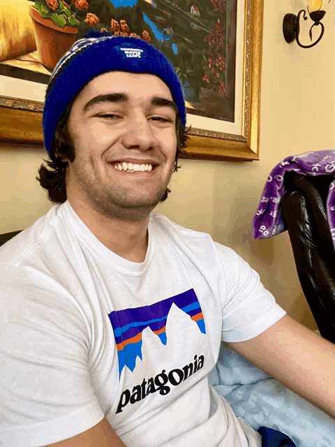 a man wearing a white patagonia shirt smiles