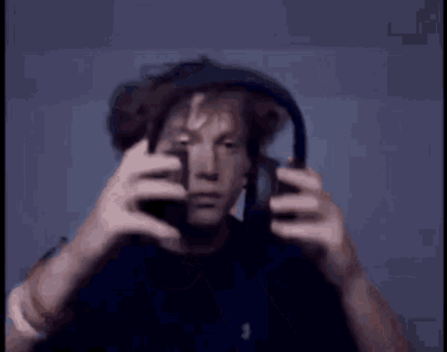 a man wearing headphones covering his face with his hand