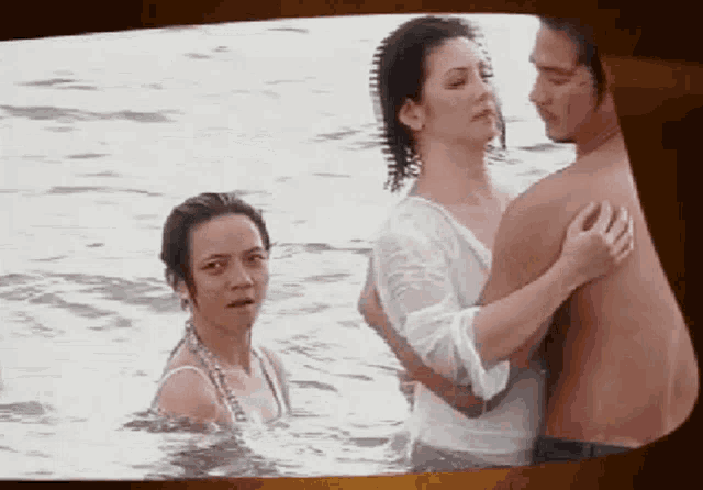 a man and two women are in the water