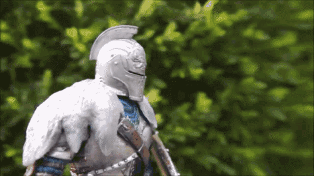 a statue of a knight wearing a helmet and a feathered coat