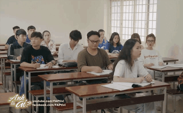 a group of students are sitting at desks in a classroom with the words anh ta ai written on the bottom