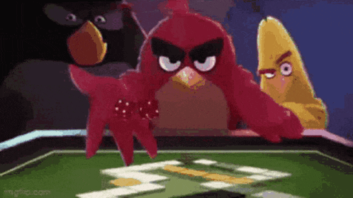 a group of angry birds are playing a game of cards .