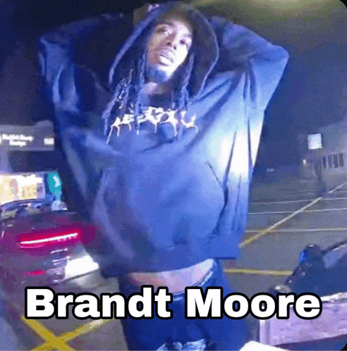 a man wearing a blue hoodie with the name brandt moore on the bottom