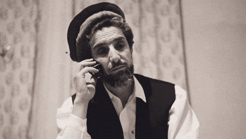 a man with a beard is talking on a cellphone