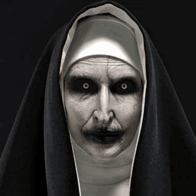 the nun from the movie the conjuring has glowing eyes and a scary face .