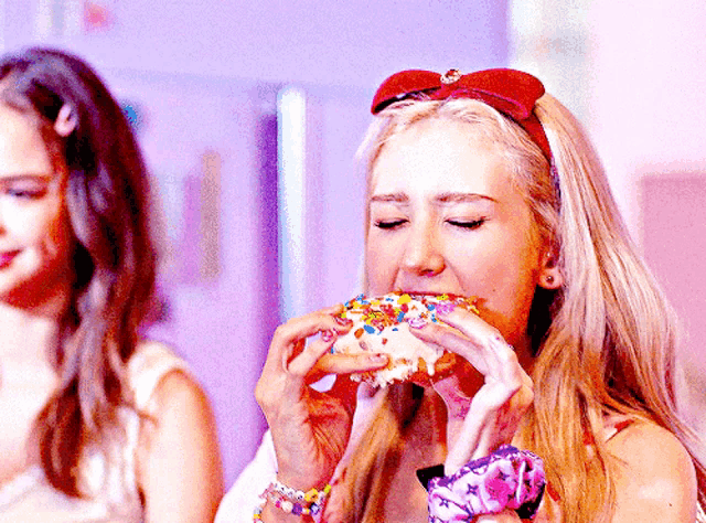 a woman is eating a donut with sprinkles