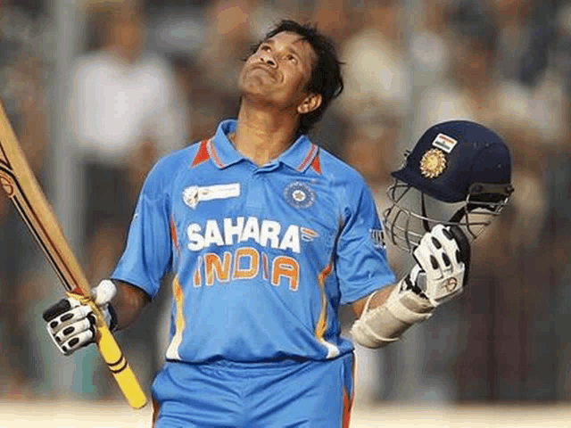 a man in a blue sahara india jersey holds his bat and helmet