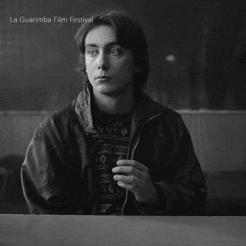 a black and white photo of a man sitting at a table with la guarimba film festival written on the bottom