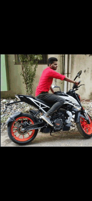 a young man in a red shirt sits on a motorcycle