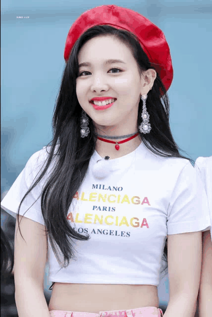 a woman wearing a red hat and a white t-shirt that says milano balenciaga paris balenciaga los angeles