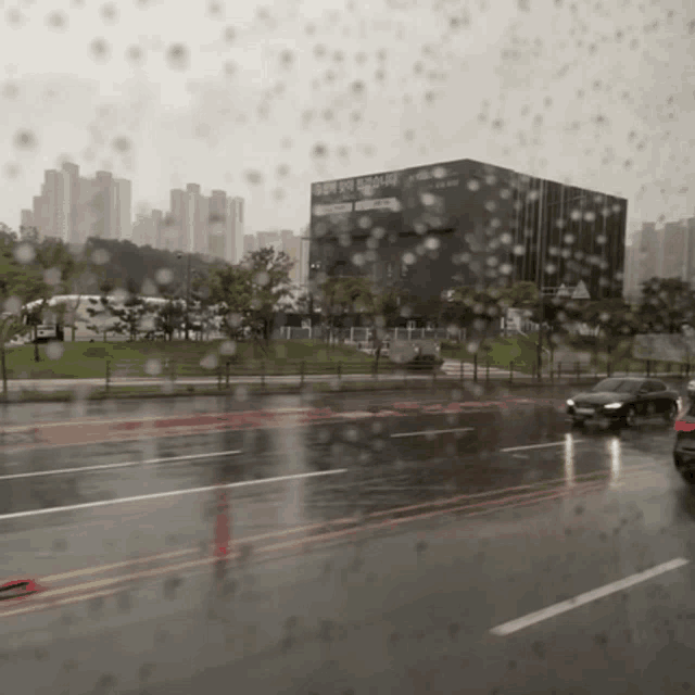 a rainy street with a building in the background that says ' seoul '