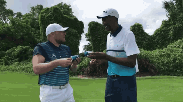 two men are standing on a golf course and one of them is wearing a shirt that says ' lacoste ' on it