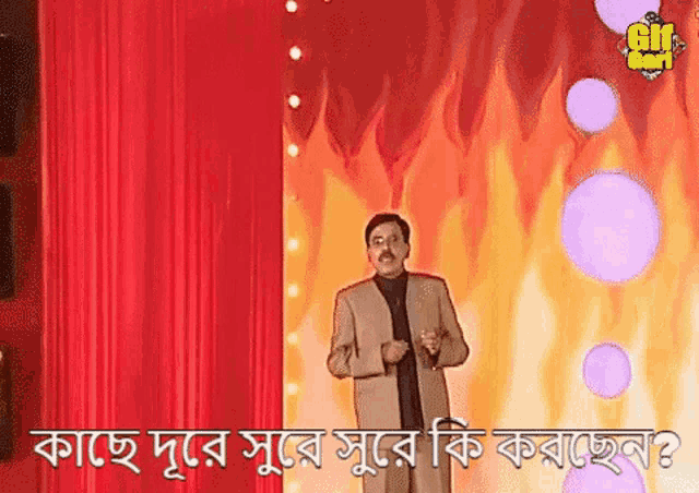 a man in a suit is standing in front of a red curtain with flames in the background