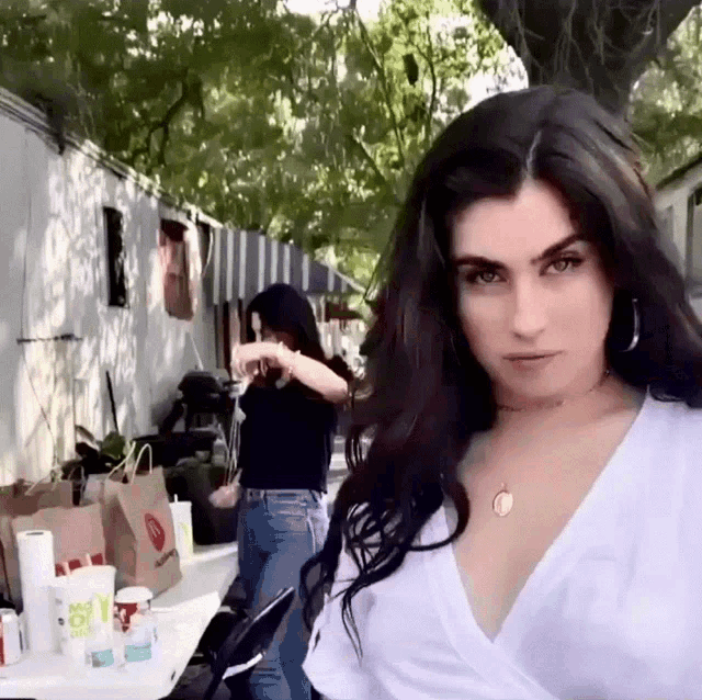 a woman in a white shirt is standing in front of a table with a mcdonald 's bag on it