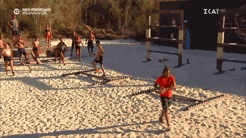 a group of people on a sandy beach with a sign that says ' scat hd ' at the top