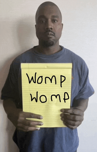 a man in a blue shirt is holding a yellow notepad with the words womp womp written on it