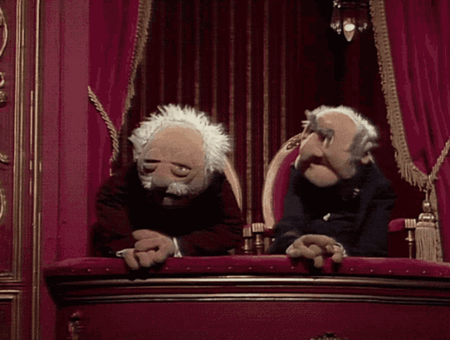 two muppets are sitting on a balcony talking